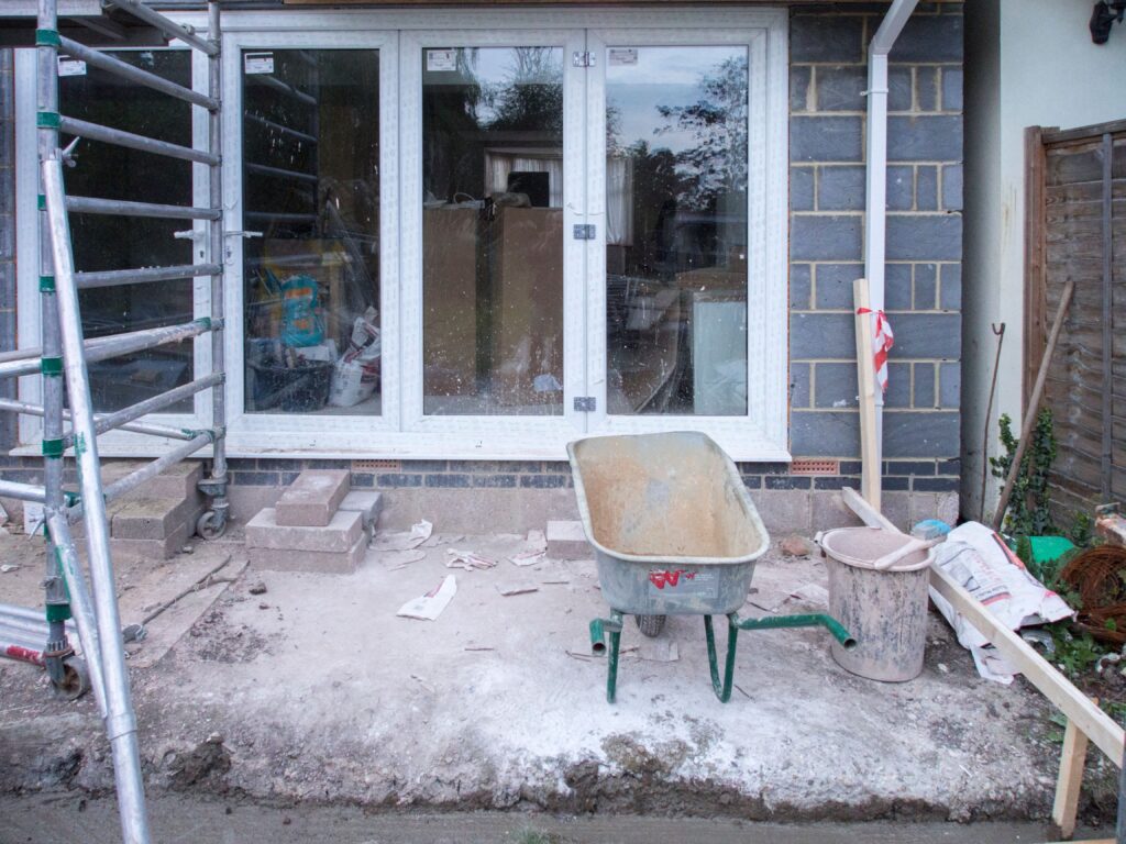 House renovation project with tools and scaffolding during a siding replacement