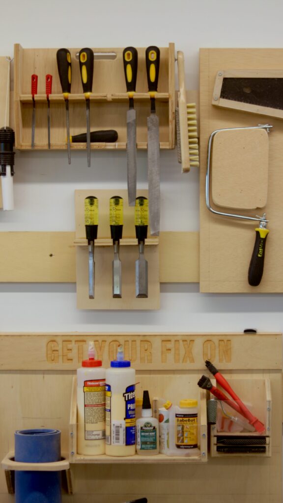 A workbench with hand tools hanging on the wall