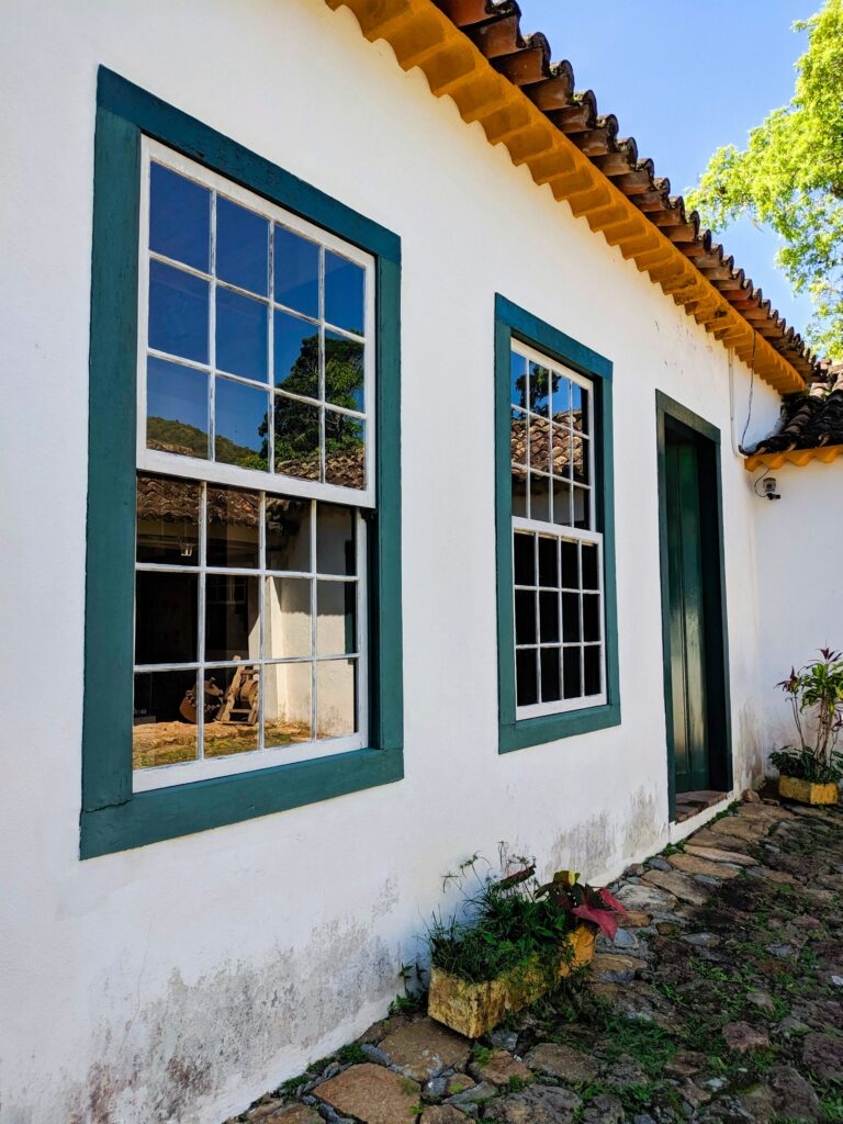 White house with green trim around windows and vinyl siding
